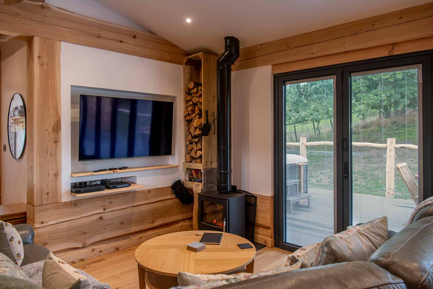 Integral Blinds for Bifold Doors: integrated blinds in bifold doors in a timber cabin with a wood-burning stove