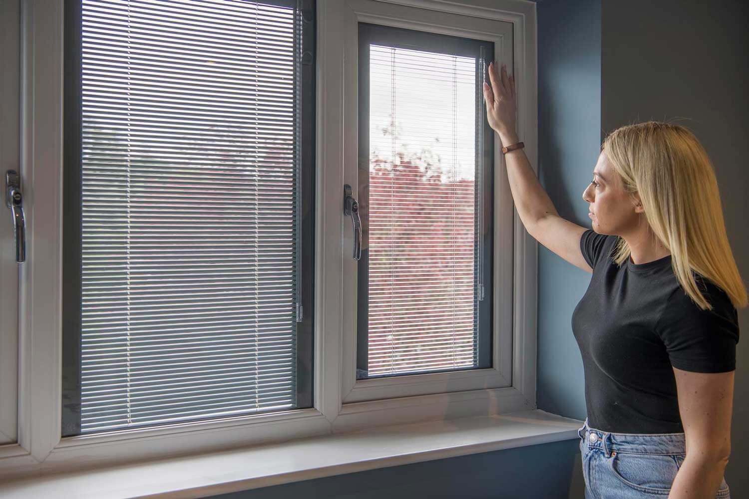 Blinds in Glass in Baldock: adjusting white venetian integral blinds in a window