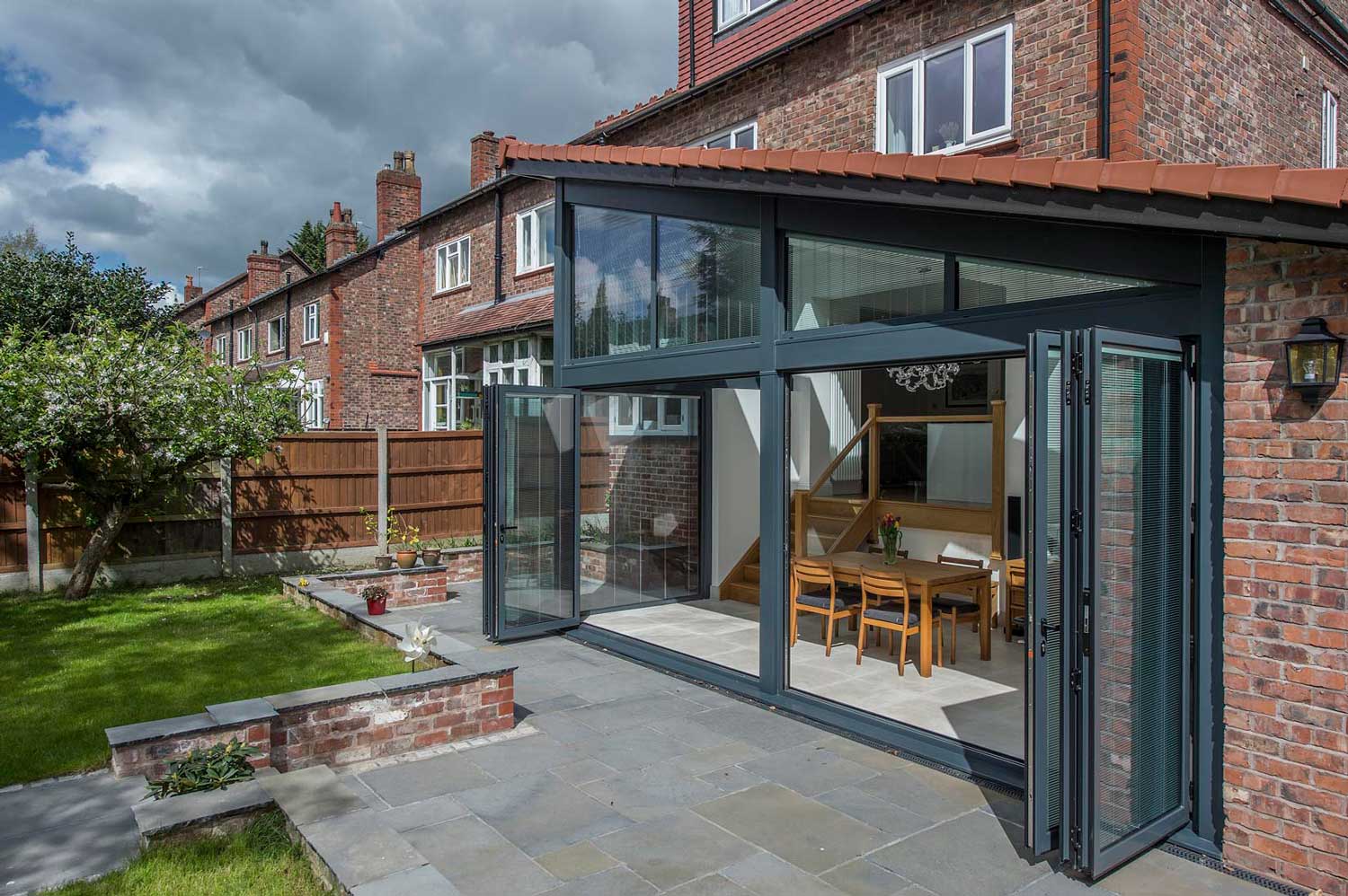 Blinds in Glass in Baldock: integral blinds in bifold doors on a brick extension opening onto a patio