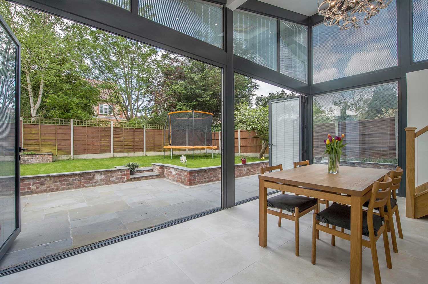 Blinds in Glass in Baldock: integral blinds in dining-room bifold doors onto a garden