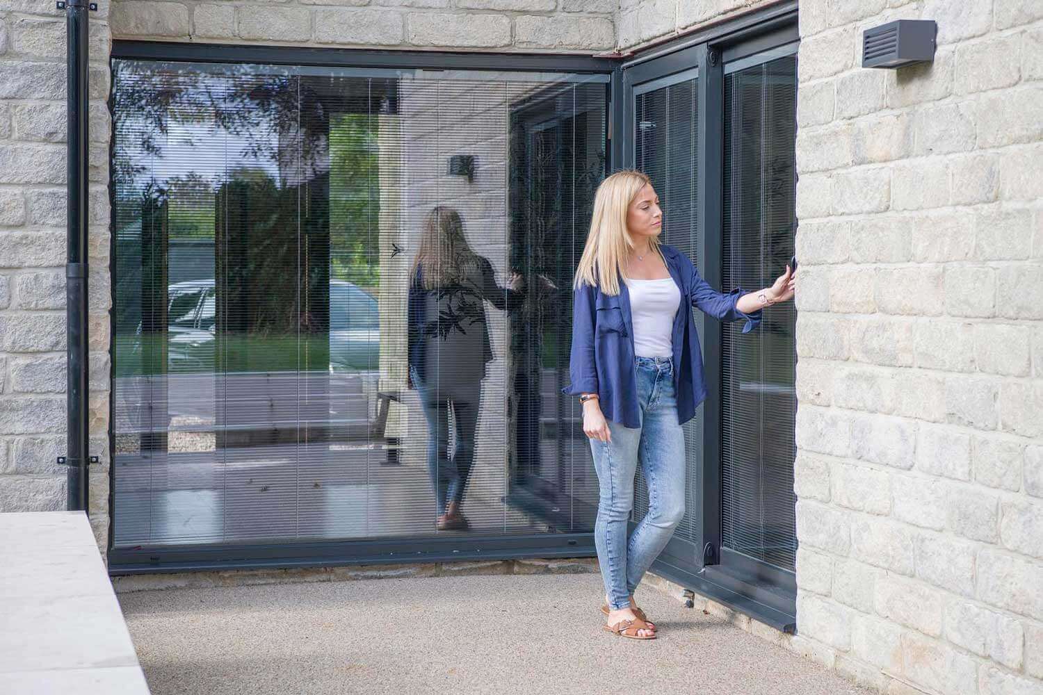 Blinds in Glass in Baldock: operating integral blinds in the bifold doors of a stone house