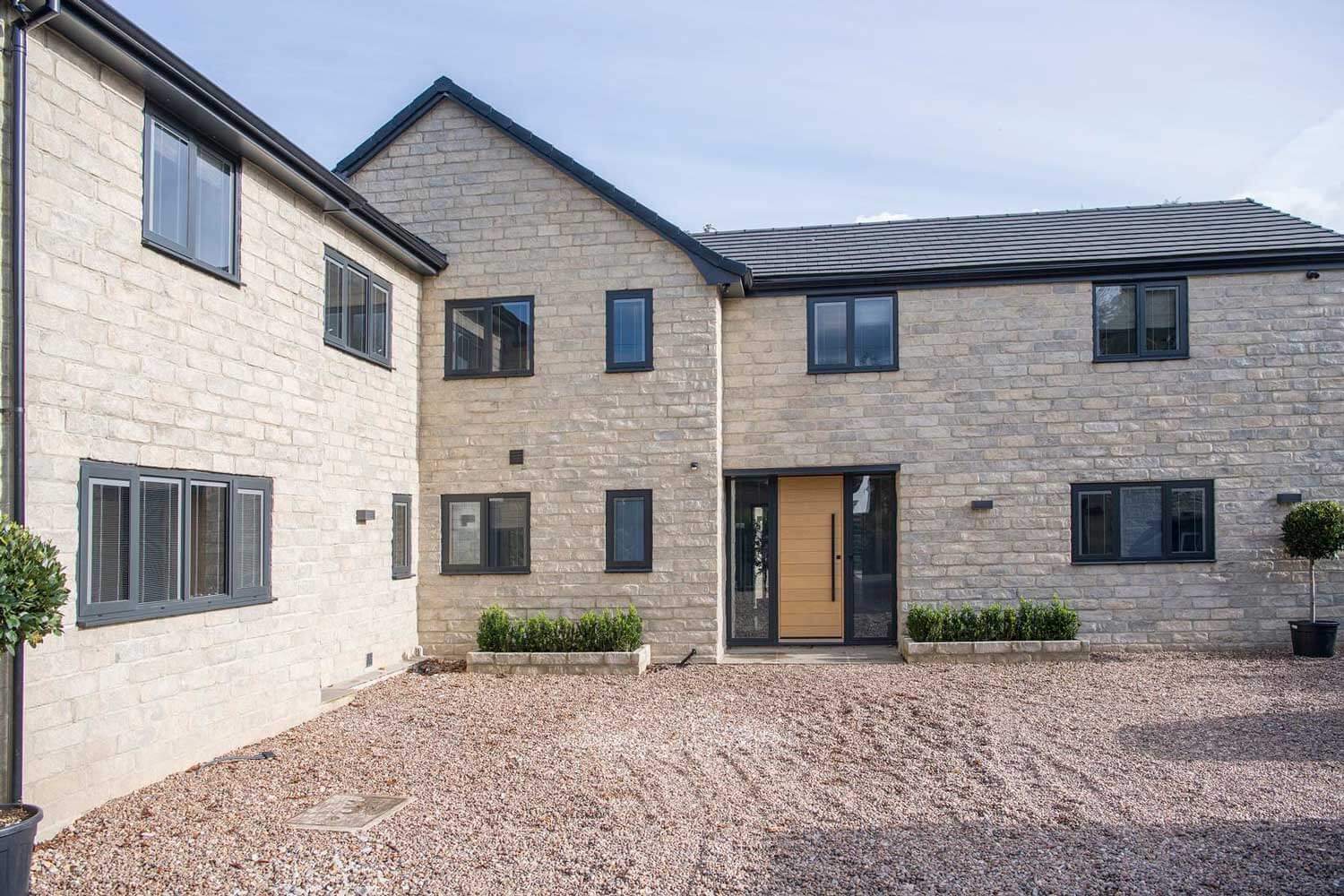 Blinds in Glass in Baldock: integral blinds in the windows of a stone house with an oak front door