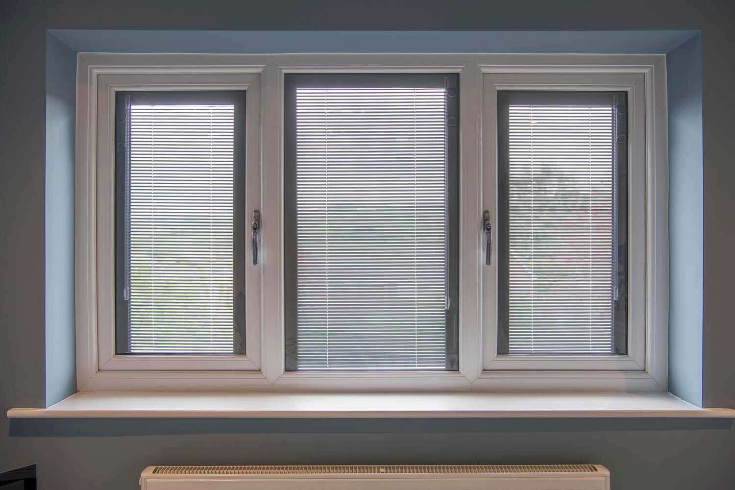 Blinds in Glass in Baldock: white venetian integral blinds in a three-panel window